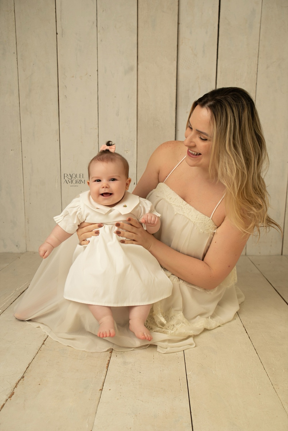 Diana, 6 meses, sentada no colo da mãe